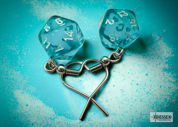 Blue dice earrings with a silver heart charm on a teal background