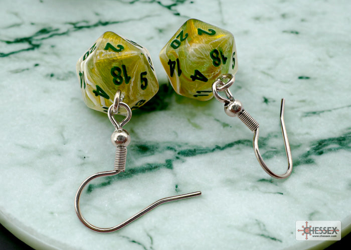 D20 dice earrings on a marble surface with Chessex logo.