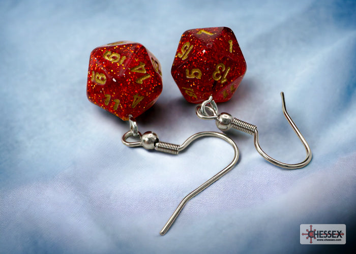 Red dice-shaped earrings with silver hooks on a light blue fabric background