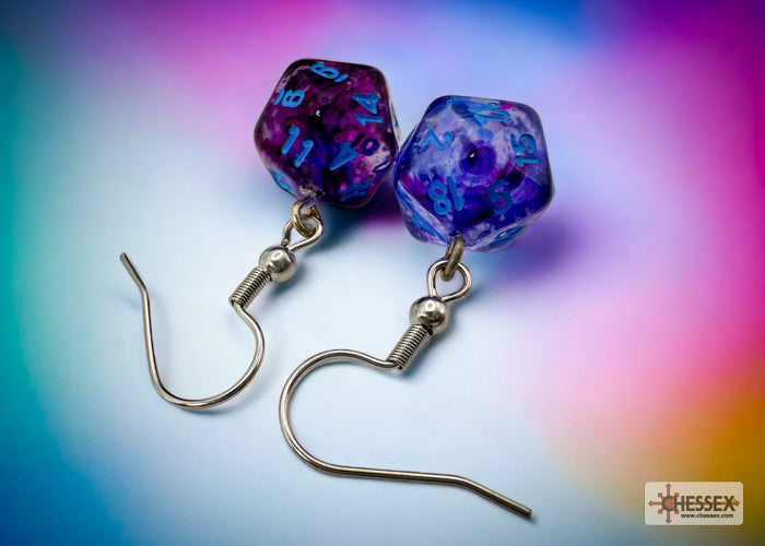Pair of purple and blue dice-shaped earrings on a colorful gradient background
