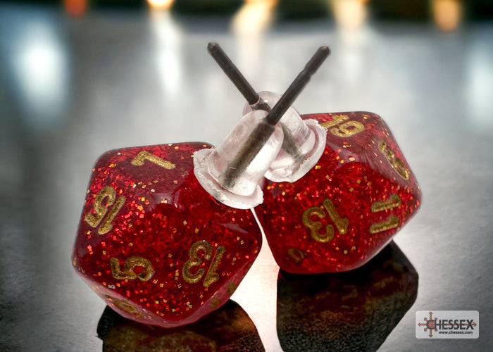 Red dice with gold numbers and white string on a reflective surface