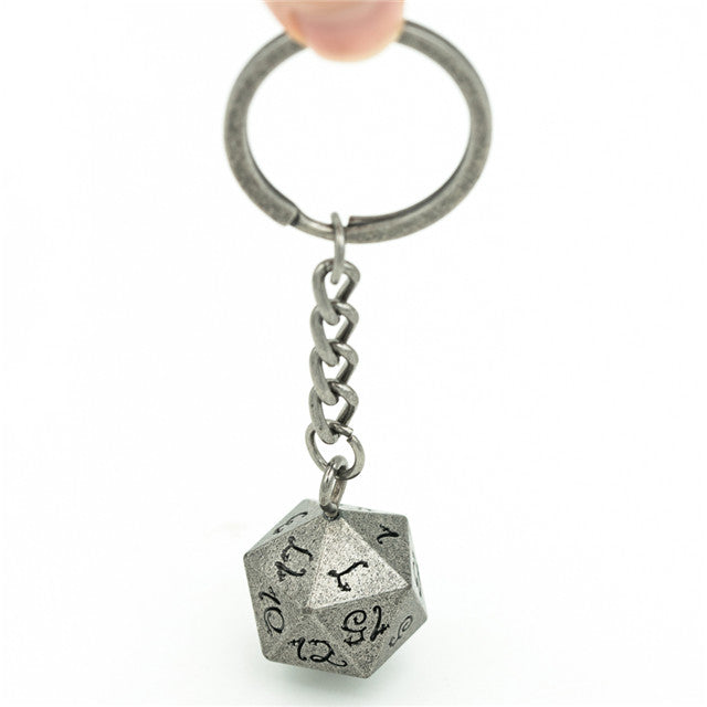 Silver polyhedral die keychain with chain on a white background