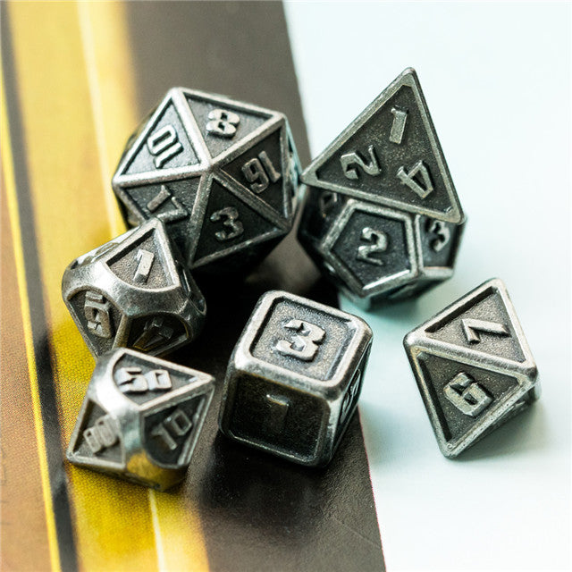 Set of metallic polyhedral dice on a reflective surface