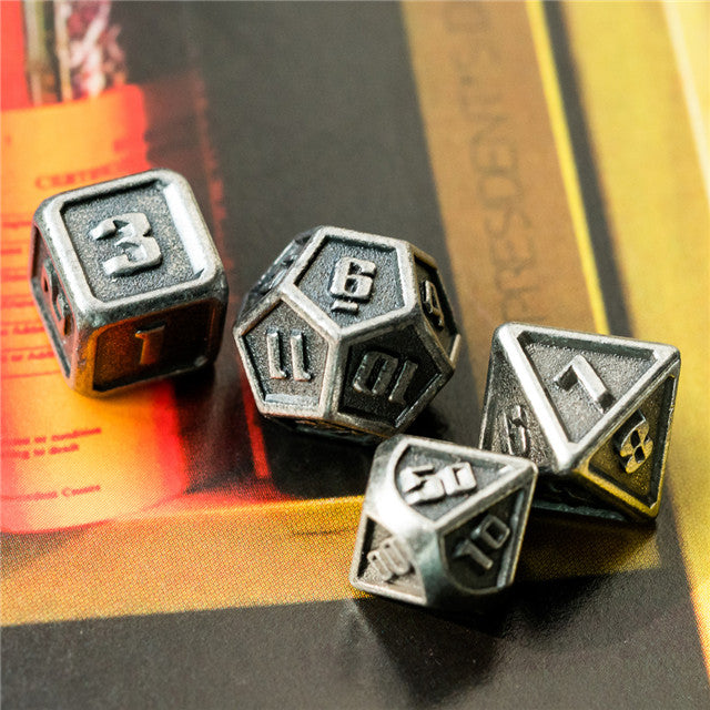 Set of metallic polyhedral dice on a gaming book