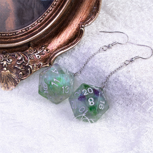 D20 dice earrings on a textured surface with an ornate object in the background