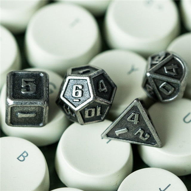 Metal dice with white lettered surface on a white background