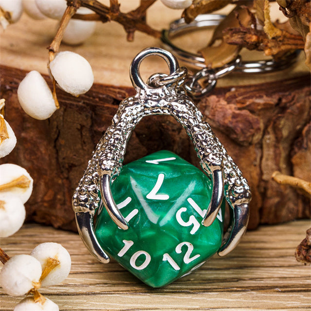 Green die-shaped pendant with silver casing on a wooden surface with decorative elements