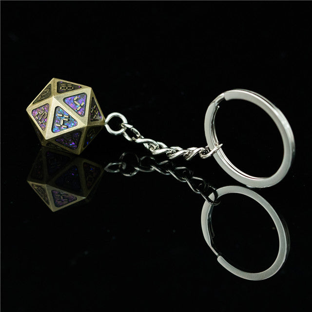 Metal polyhedral dice keychain with a reflective surface on a black background
