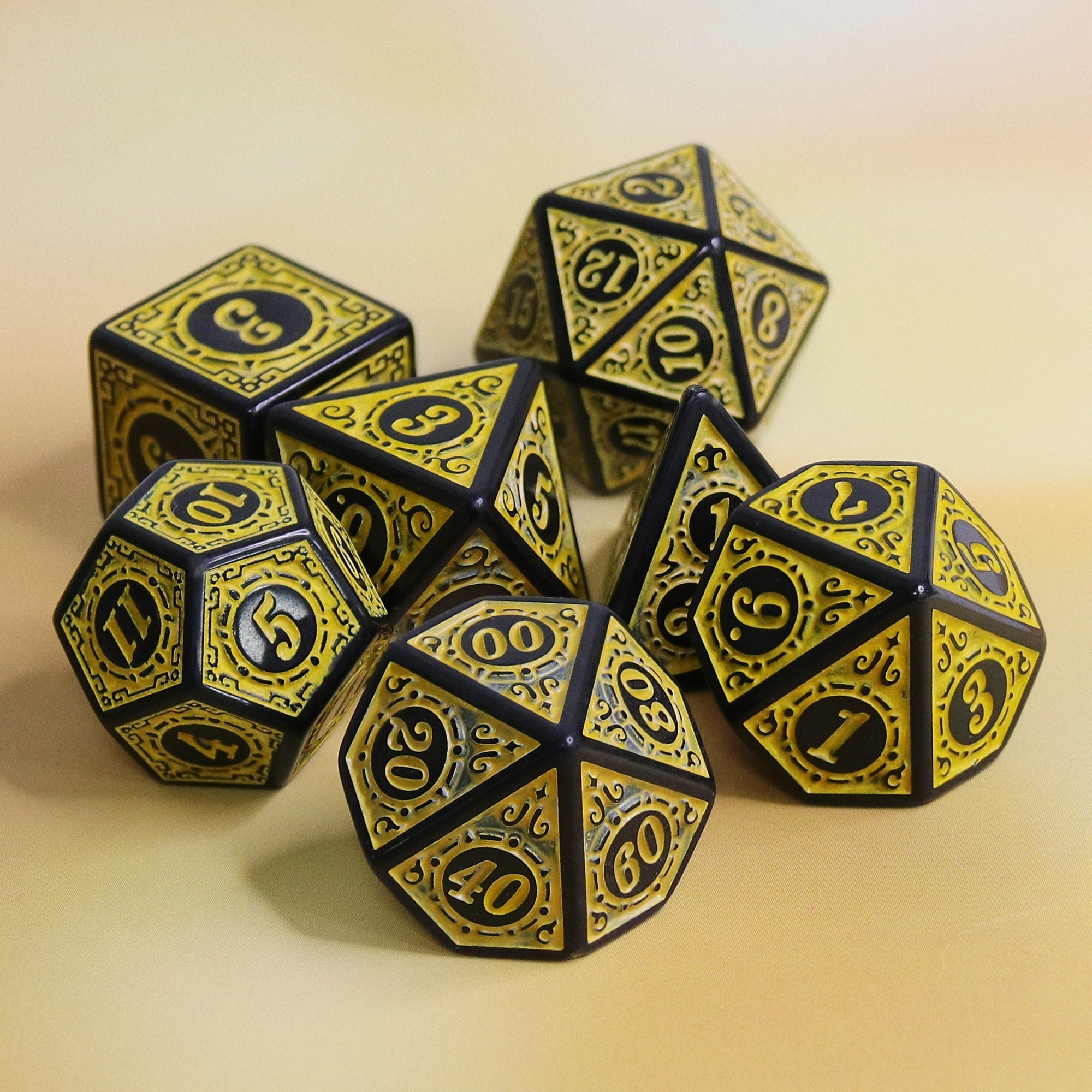 Set of black and gold polyhedral dice on a beige background