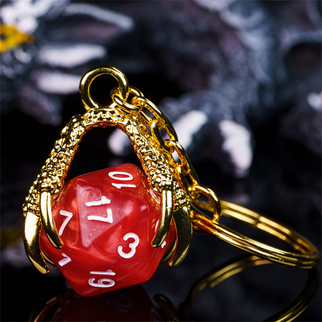 Red die-shaped keychain with gold frame on a dark background