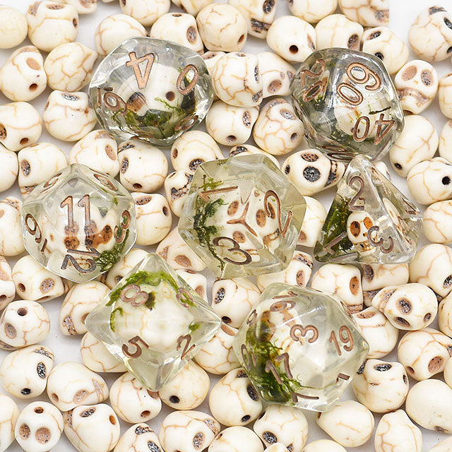 Set of dice with mossy texture on a bed of small beige stones