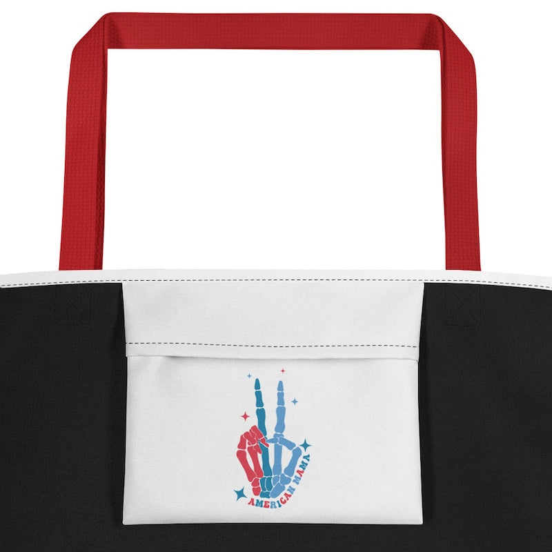 Tote bag with red handles, white front panel with hand design, and black sides.