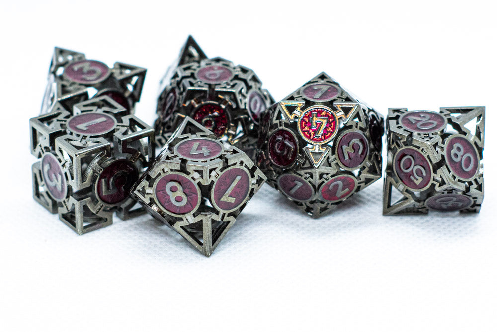 Set of metal dice with pink and red numbering on a white background