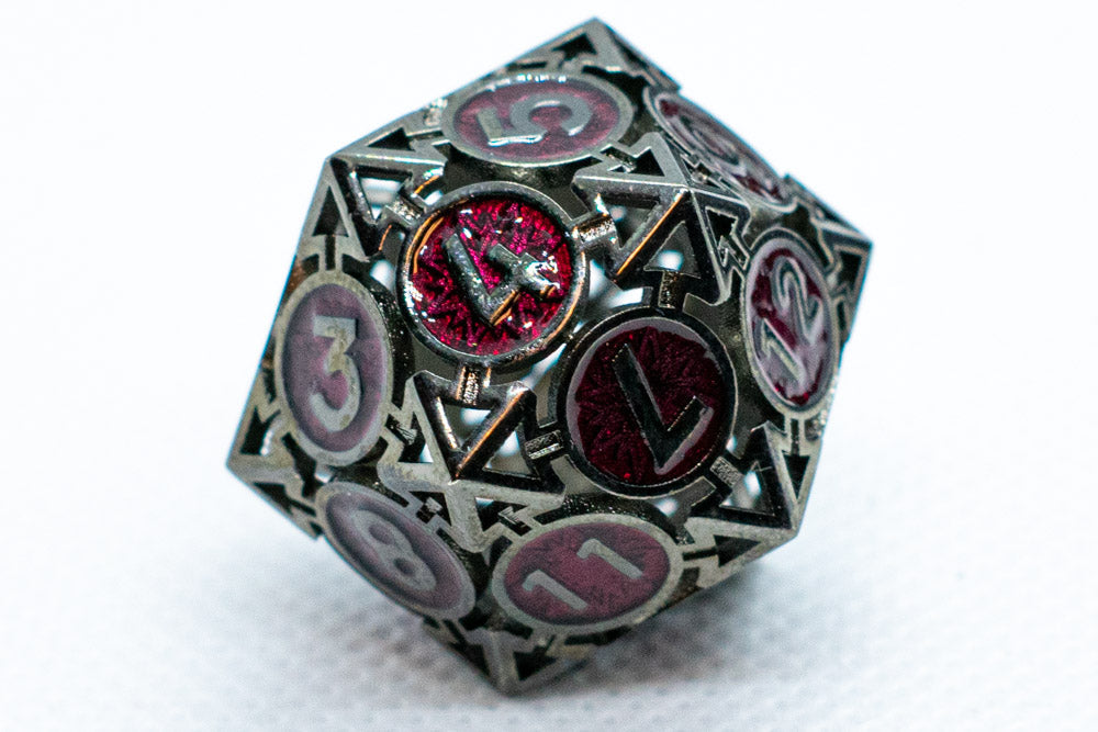 D20 polyhedral dice with metallic finish and red gem on a white background