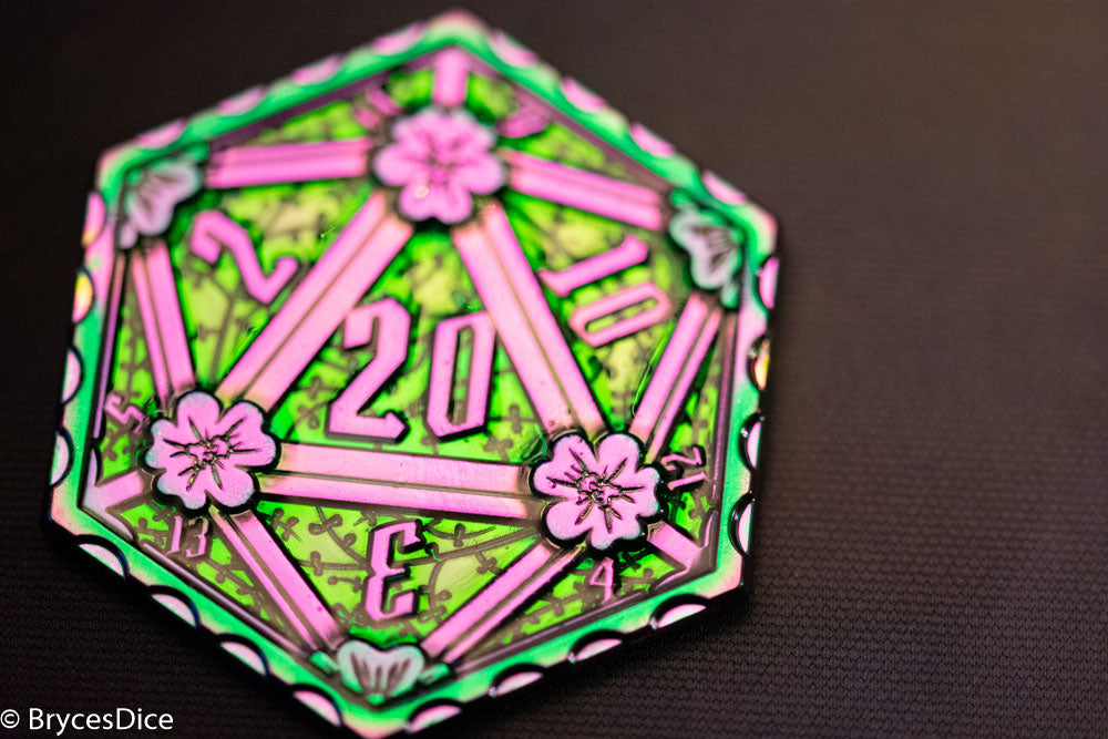 Decorative die with pink and green design on a dark background