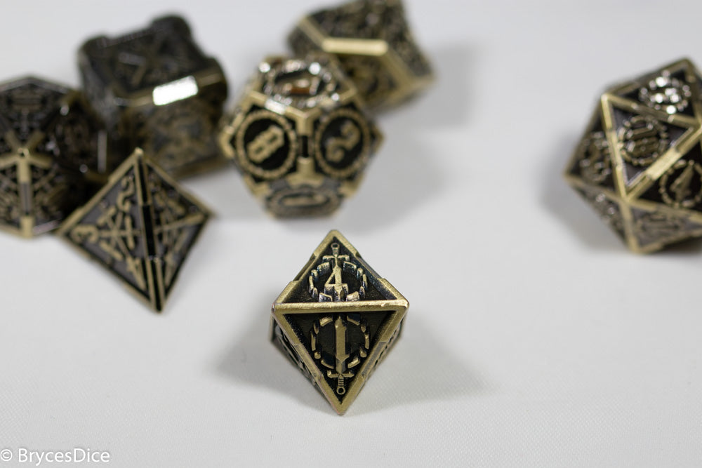 Set of ornate metal dice with intricate designs on a white background