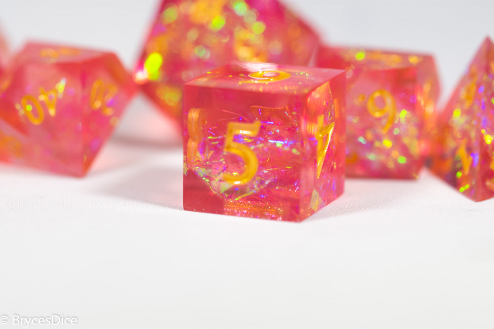 Pink and orange dice with yellow numbers on a white background