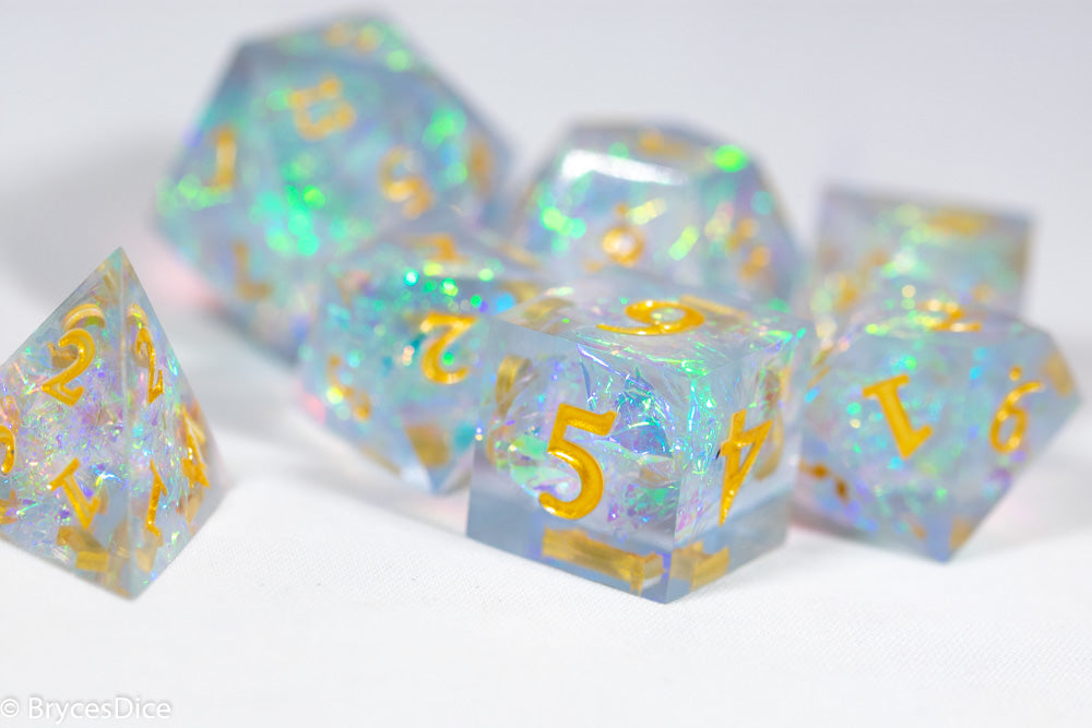 Set of iridescent polyhedral dice with gold numbers on a white background