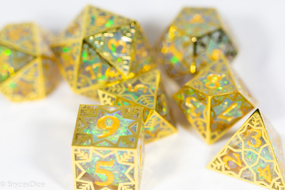Gold polyhedral dice set with iridescent numbers on a white background
