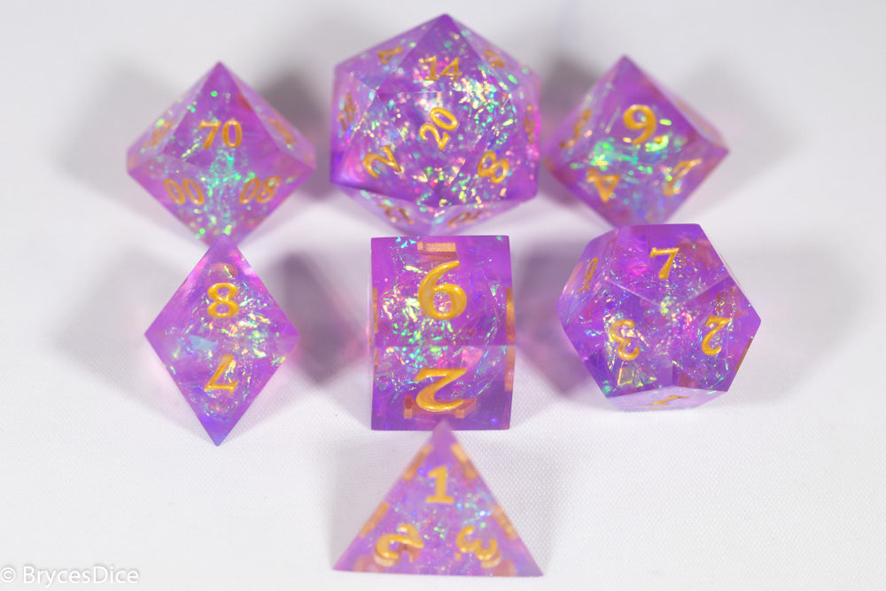 Set of purple polyhedral dice with gold numbers on a white background