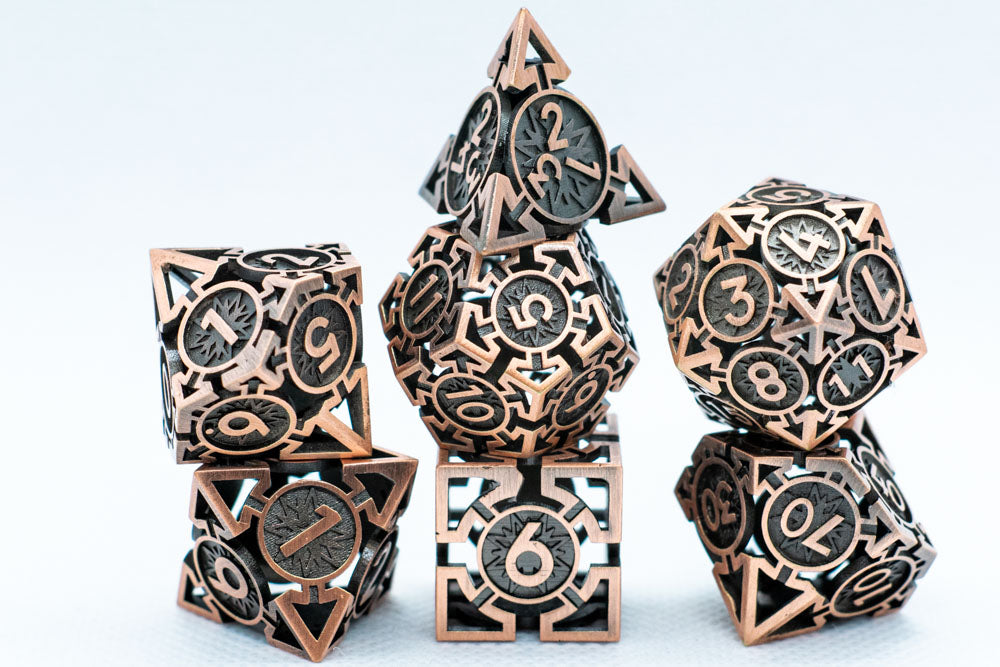 Set of metallic polyhedral dice with intricate designs on a light gray background