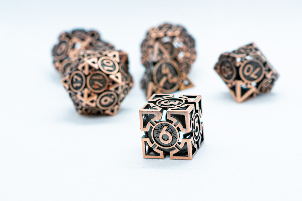 Decorative bronze dice with intricate designs on a white background