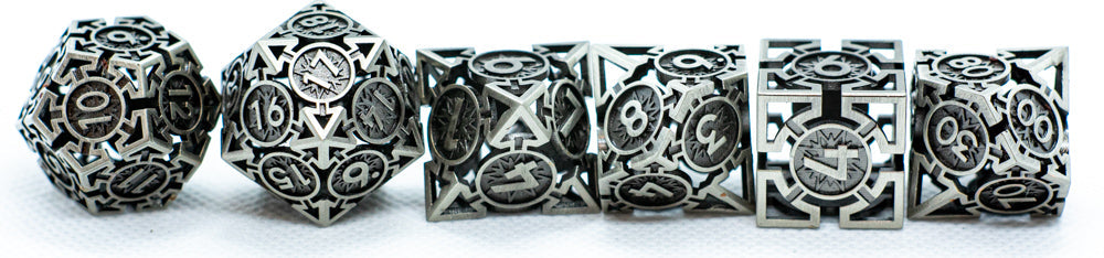 Set of silver metal dice and beads with intricate designs on a white background