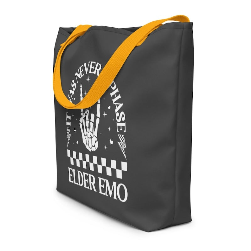 Black tote bag with yellow handles featuring a graphic design and text on a white background