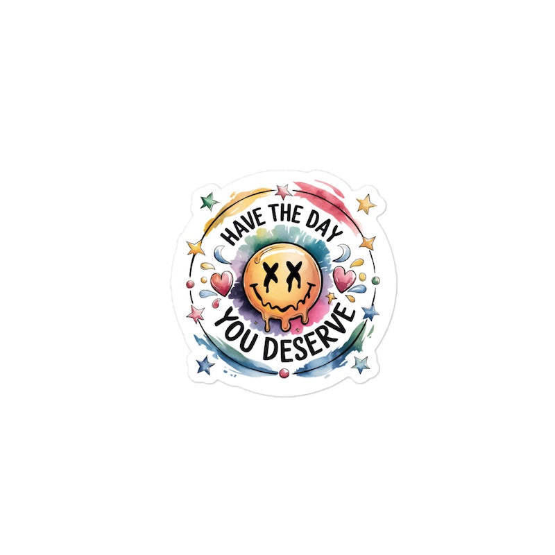 Sticker with smiley face and text 'Have the day you deserve' on a white background