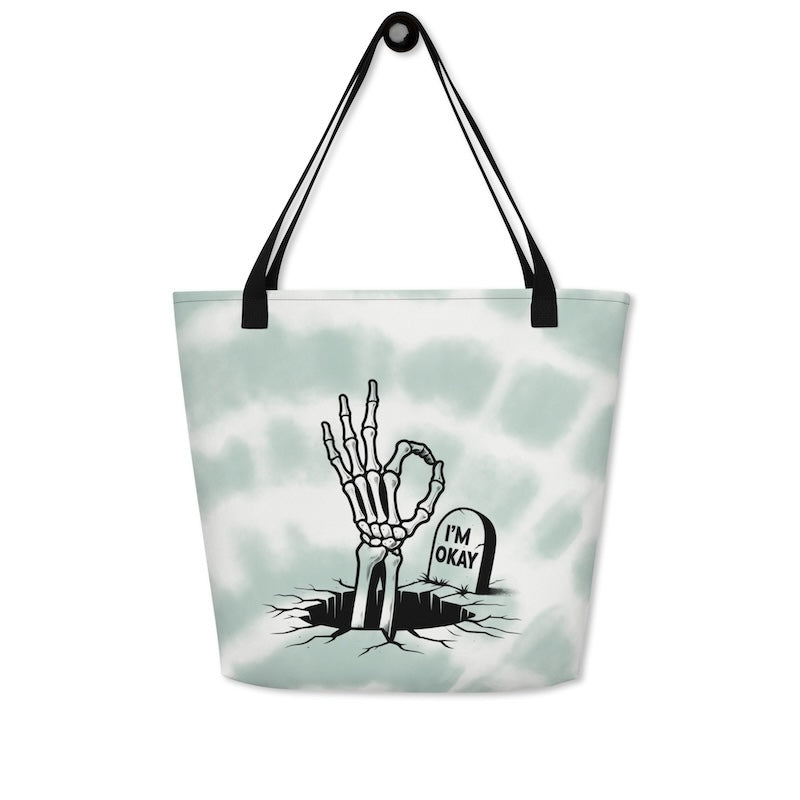 Tote bag with skeleton hand and 'I'm Okay' gravestone design on a light green background