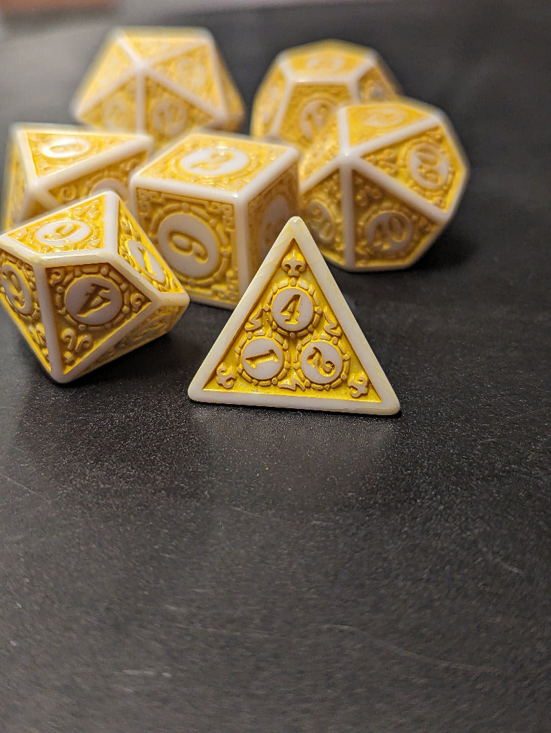 Set of ornate dice with gold and white design on a dark surface
