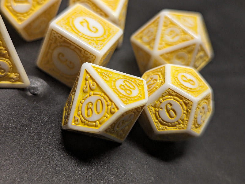 Set of dice with yellow and white numbers on a dark surface