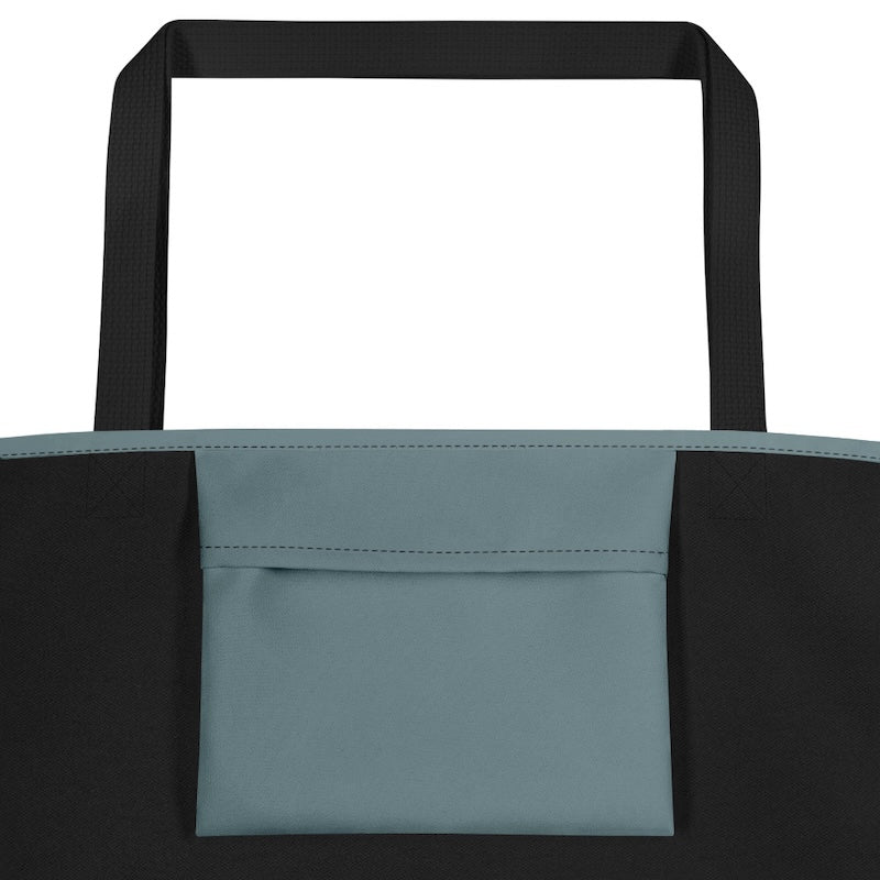 Close-up of a tote bag with black handles and a teal pocket on a white background