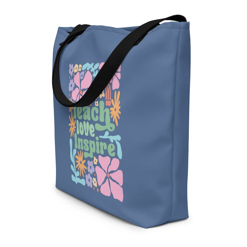 Blue tote bag with colorful text and floral designs on a white background
