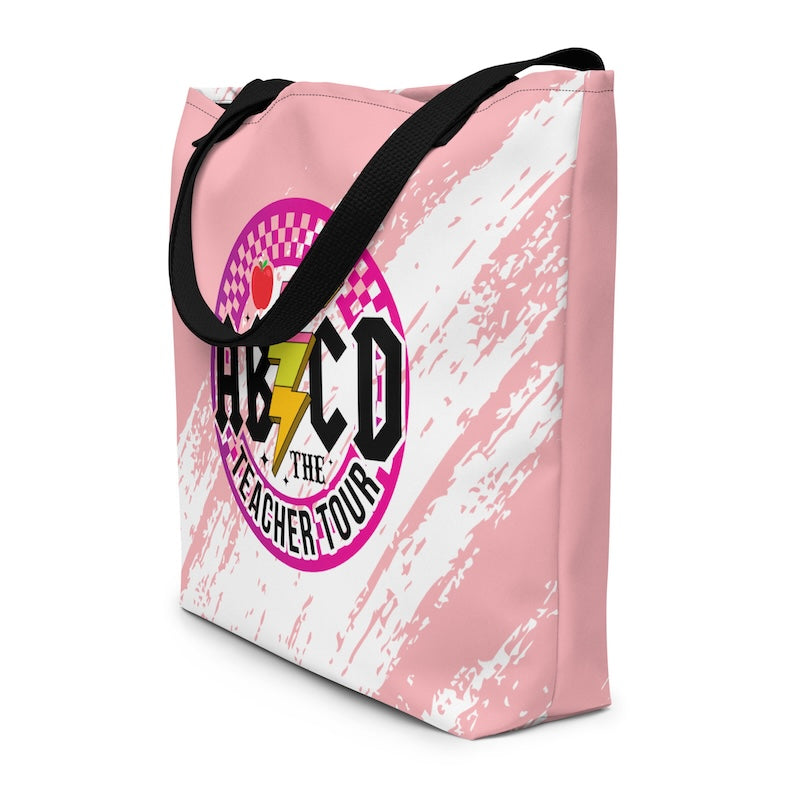 Pink tote bag with black handles featuring a colorful logo and text on a white background