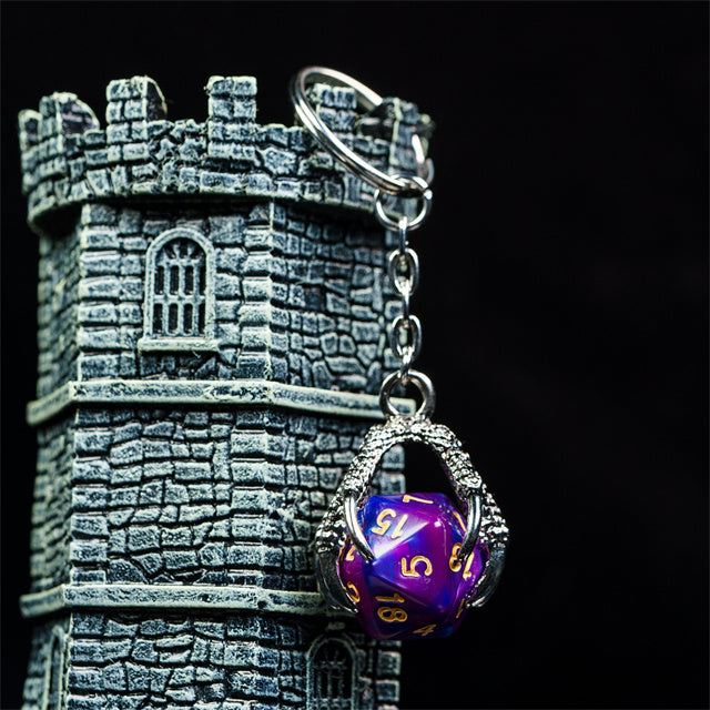 Keychain with a purple die and silver castle-shaped keyring on a black background