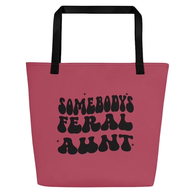 Pink tote bag with black text and handles on a white background