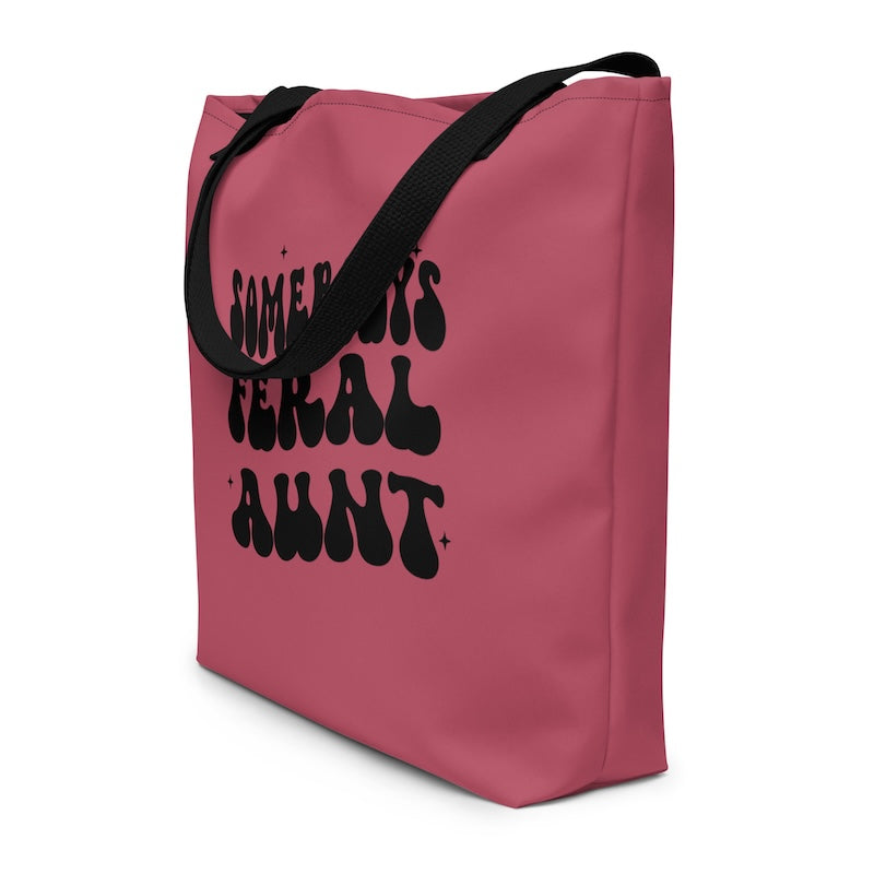 Pink tote bag with black text on a white background