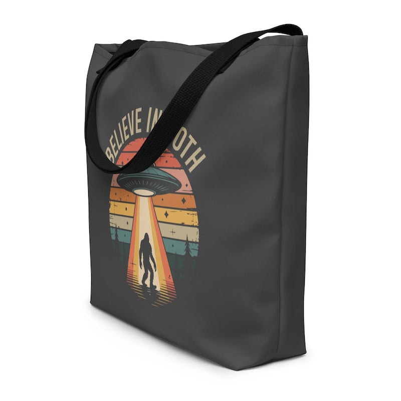 Black tote bag with UFO and alien graphic and 'BELIEVE IN UTH' text on a white background