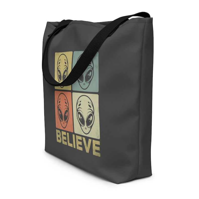 Tote bag with alien design and 'BELIEVE' text on a white background