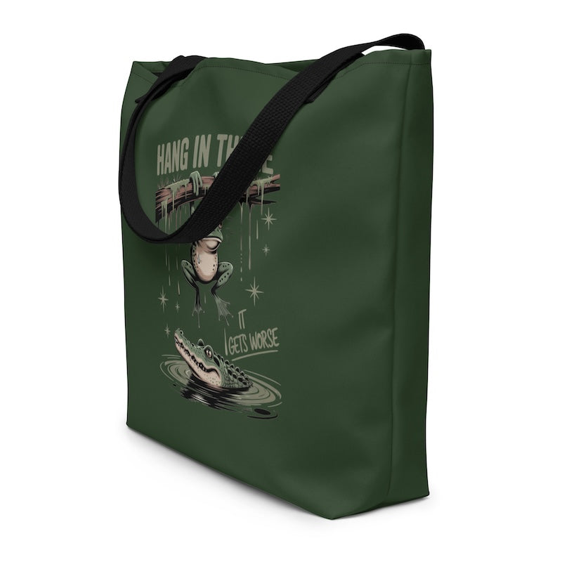 Green tote bag with graphic design of a fish and alligator, text 'Hang in the' and 'Gets worse'.