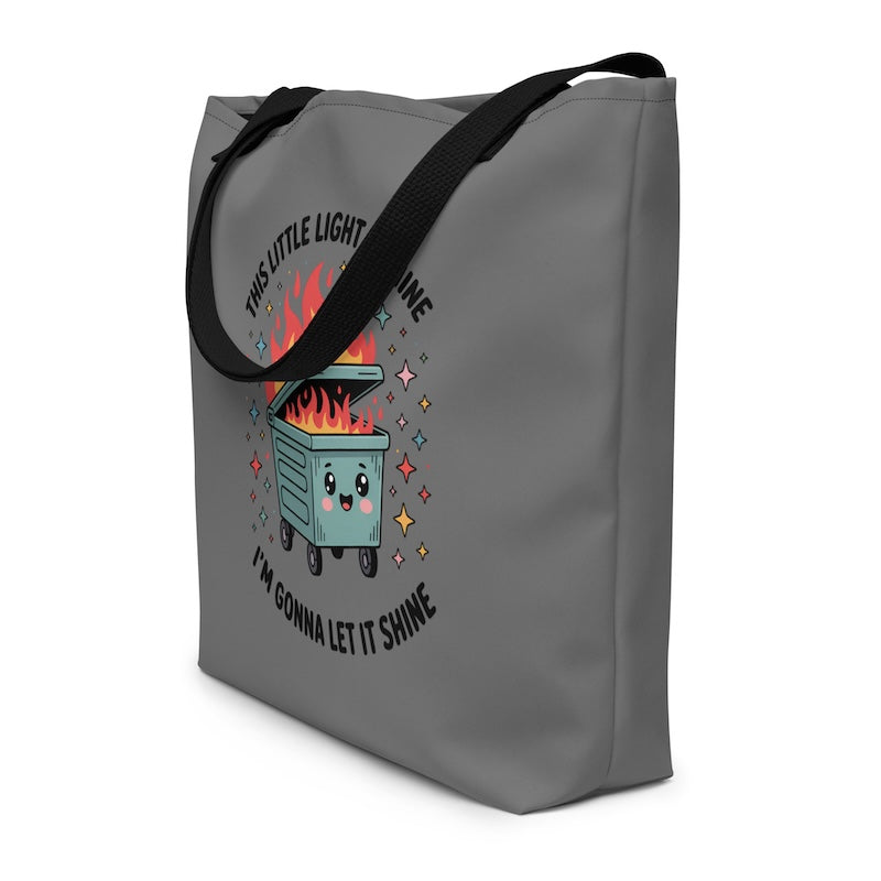Gray tote bag with a cartoon dumpster and text design on a white background