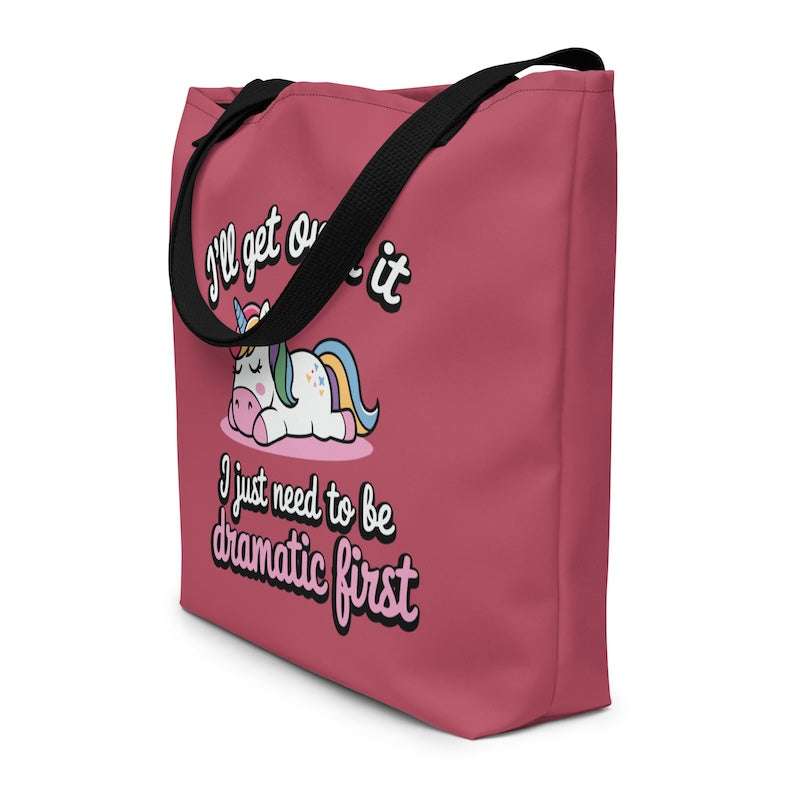 Pink tote bag with a unicorn graphic and text on a white background