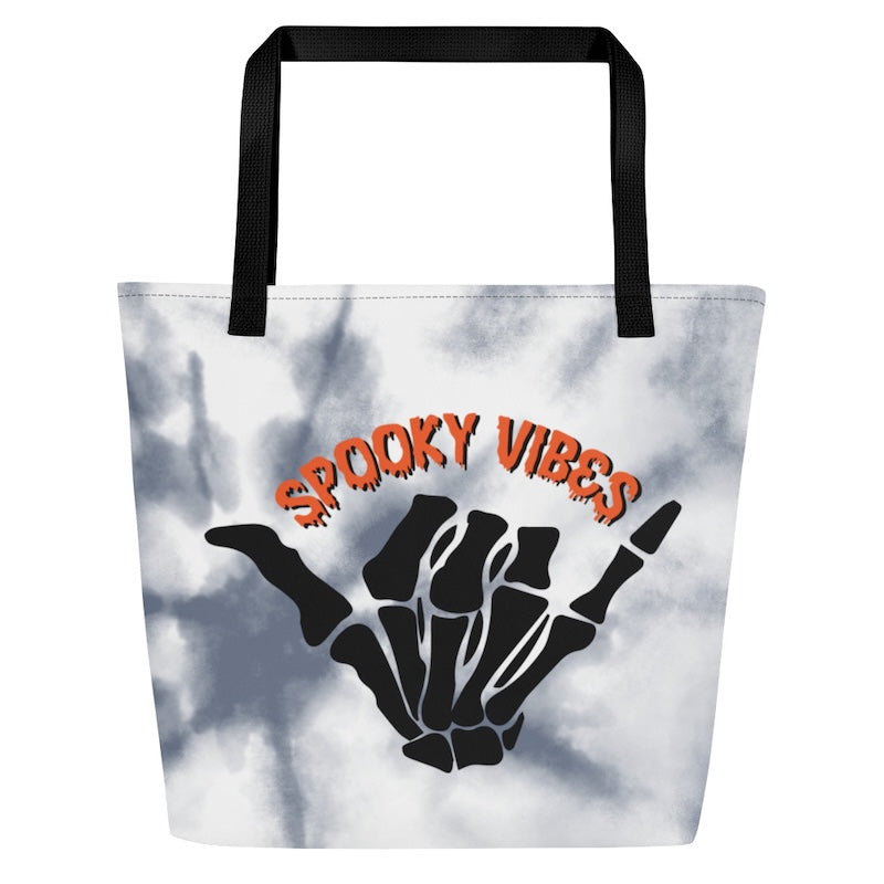 Tote bag with skeleton hand and 'Spooky Vibes' text on a tie-dye background