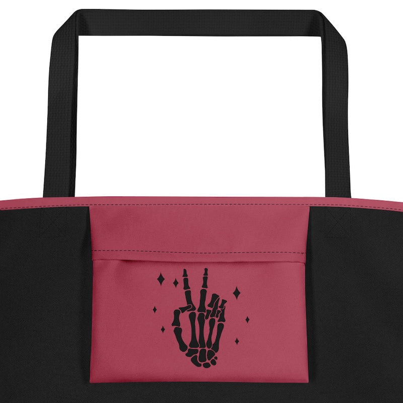 Black and pink tote bag with skeleton hand design on a white background