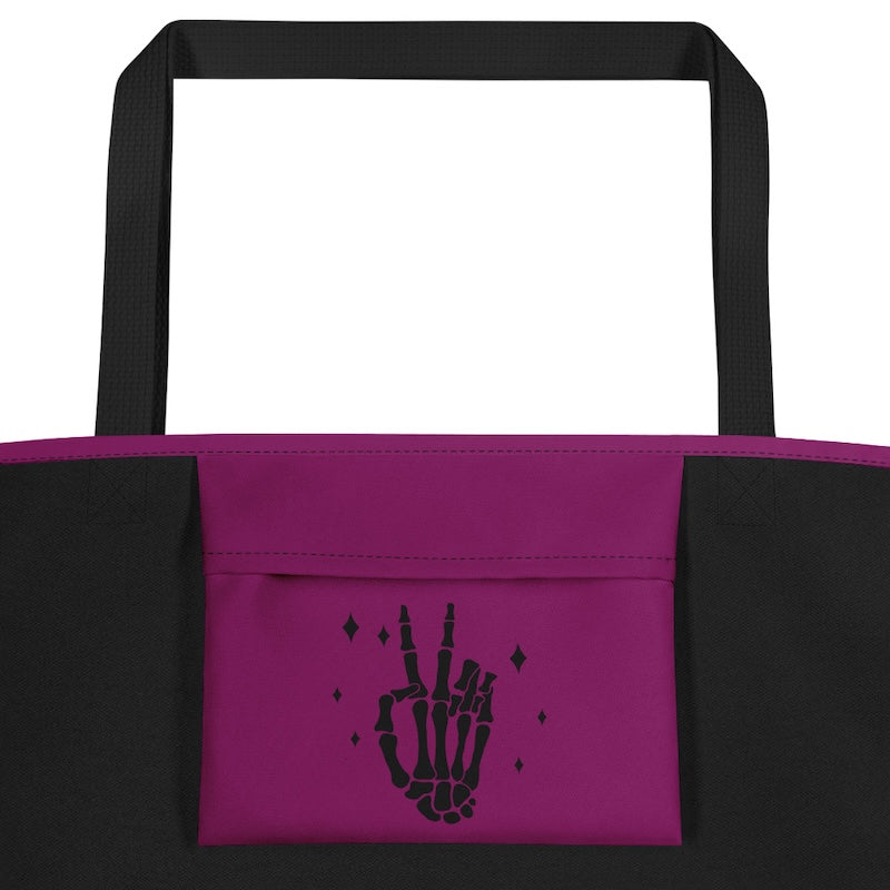 Black and purple tote bag with a skeleton hand design on a white background