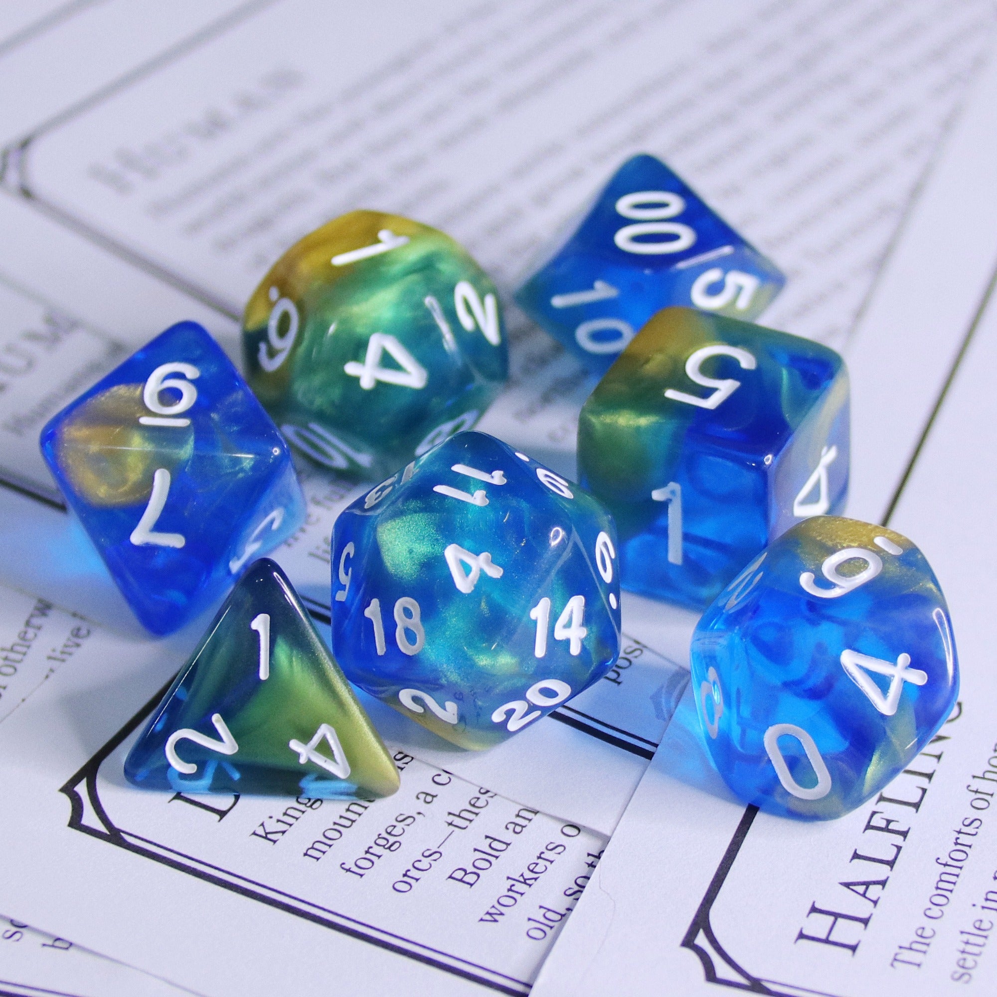 Set of blue and green polyhedral dice on a printed paper background