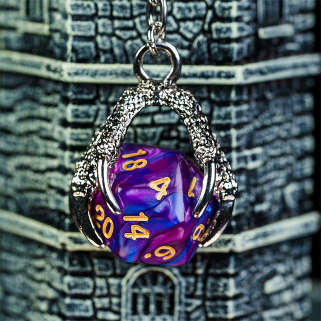 Purple polyhedral die charm with gold numbers on a textured background