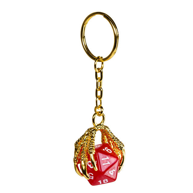 Gold keychain with a red die on a white background