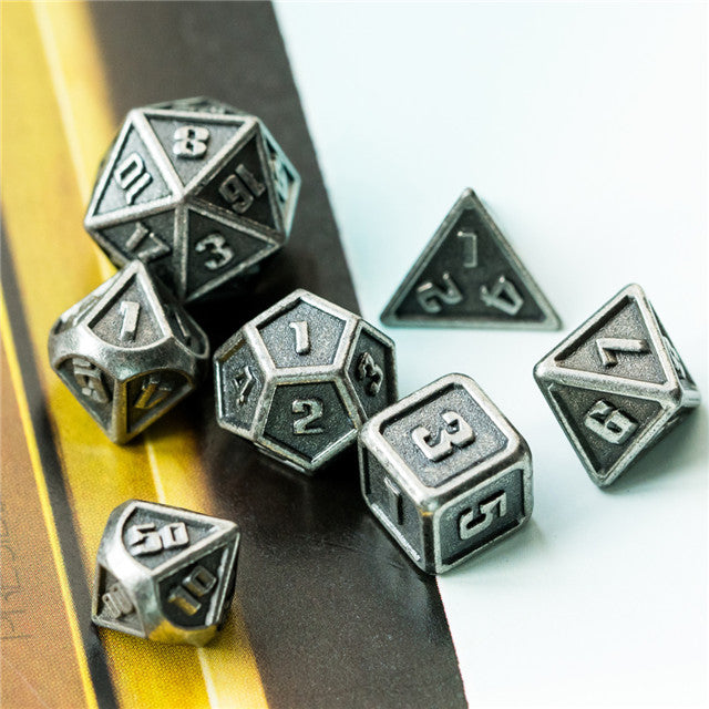 Set of metallic polyhedral dice on a wooden surface